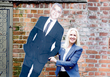 Julie Redmond with a campaign prop pretends to dispense with Mayor of London Sadiq Khan